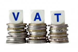 Stacks of coins with the letters VAT isolated on white background